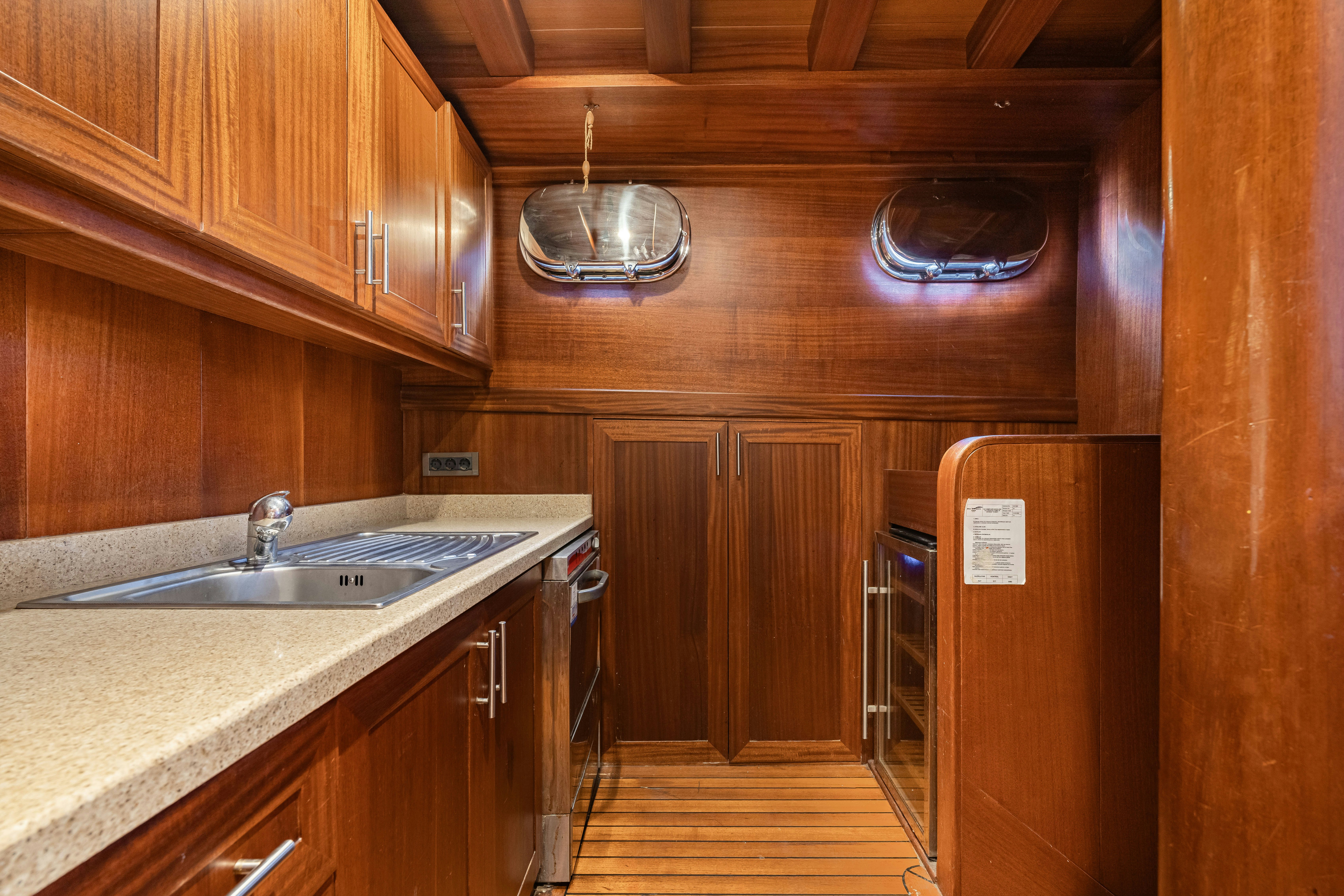 a kitchen with wooden cabinets aboard CAKIRYILDIZ Yacht for Sale
