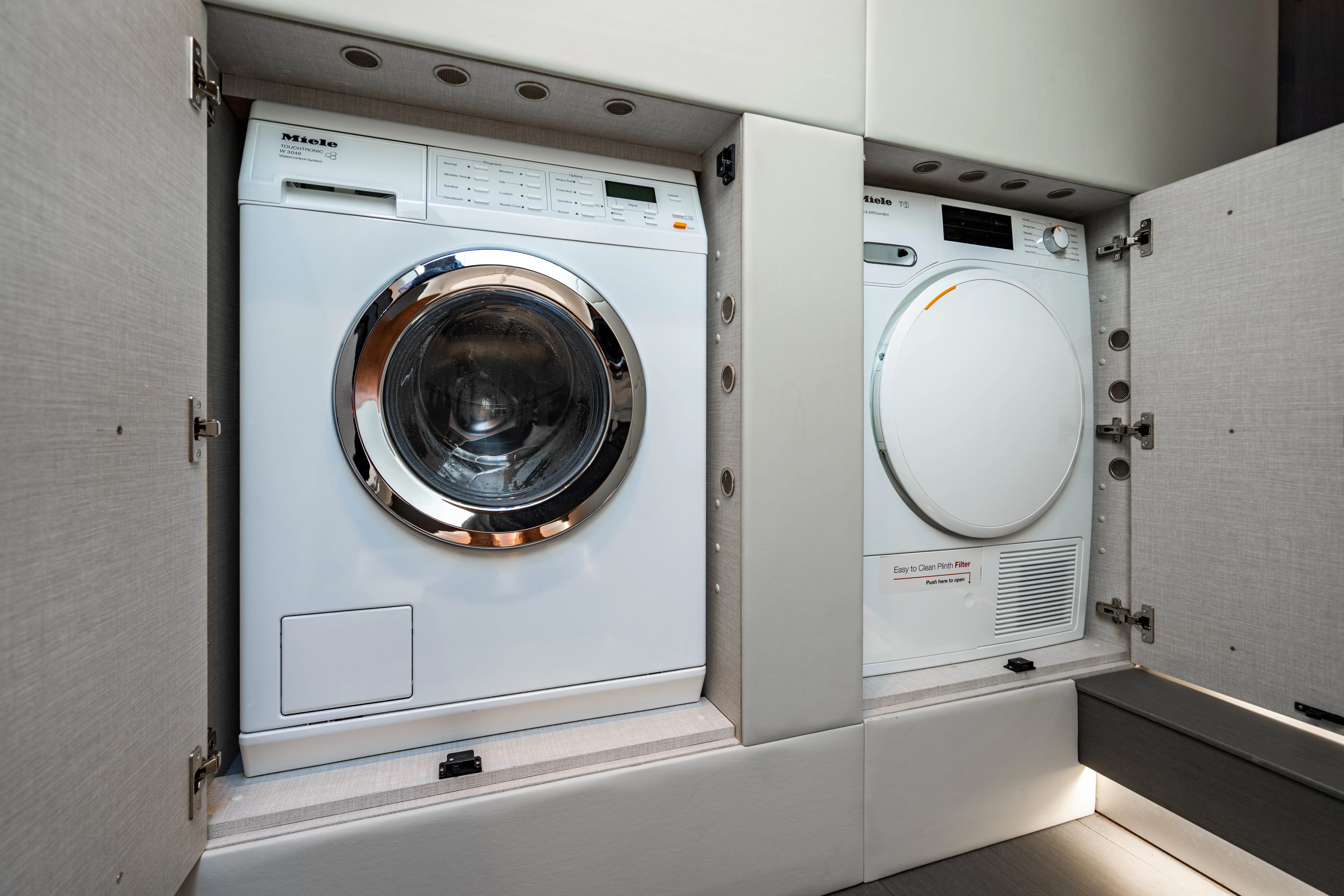 a row of white washing machines aboard ESCAPIST Yacht for Sale