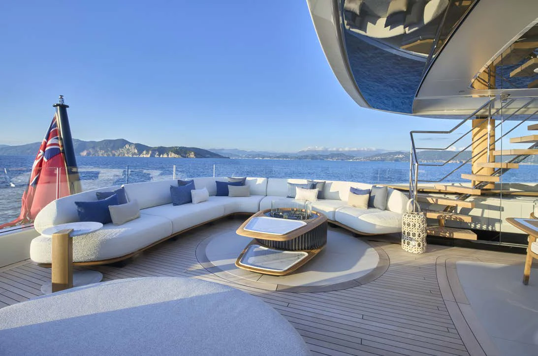 a lounge area with a large sofa and a large body of water aboard AWANDRA Yacht for Charter
