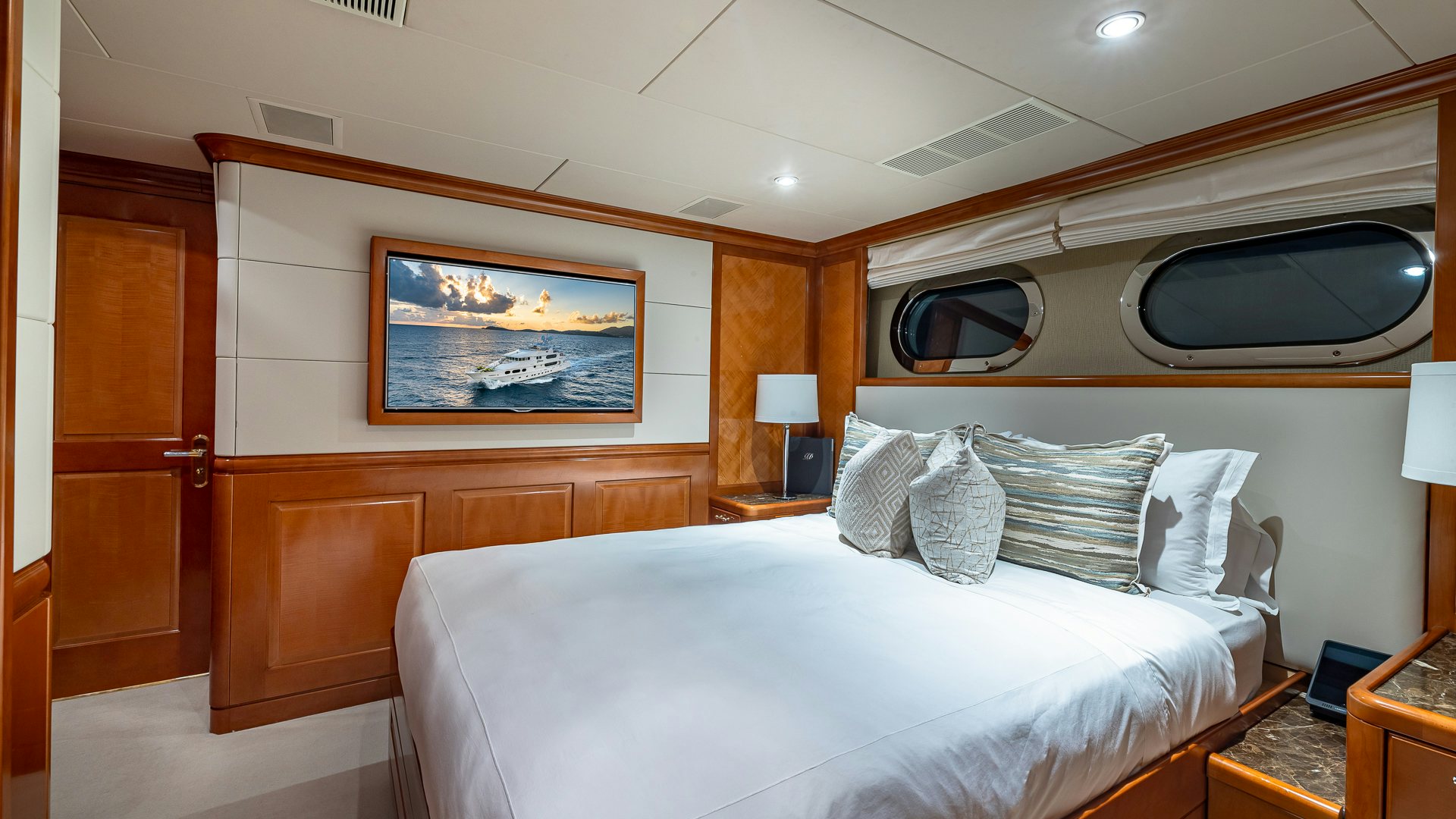 a room with a bed and a television aboard MILESTONE Yacht for Charter