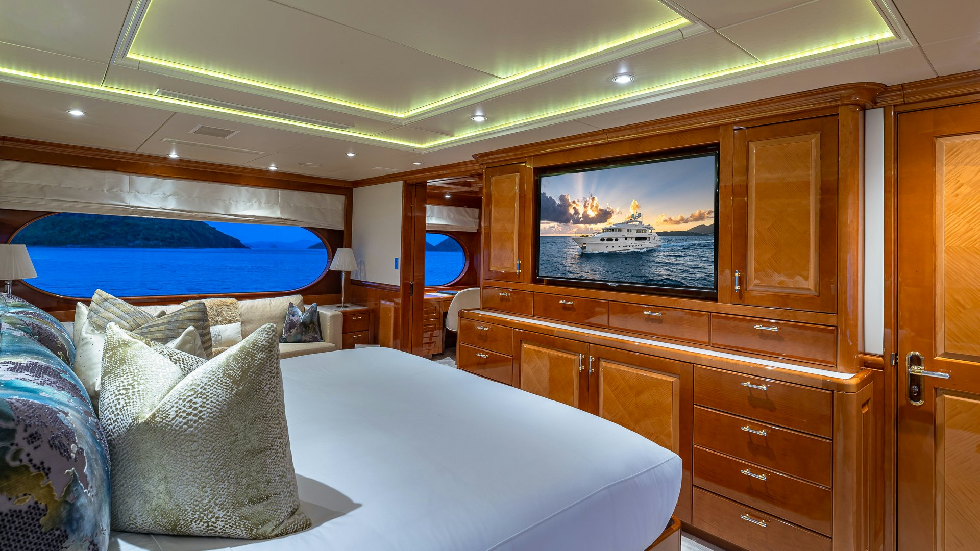 a room with a bed and a television aboard MILESTONE Yacht for Charter