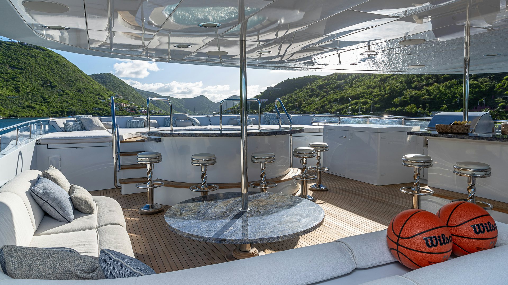 a large patio with a table and chairs and a large window aboard MILESTONE Yacht for Charter