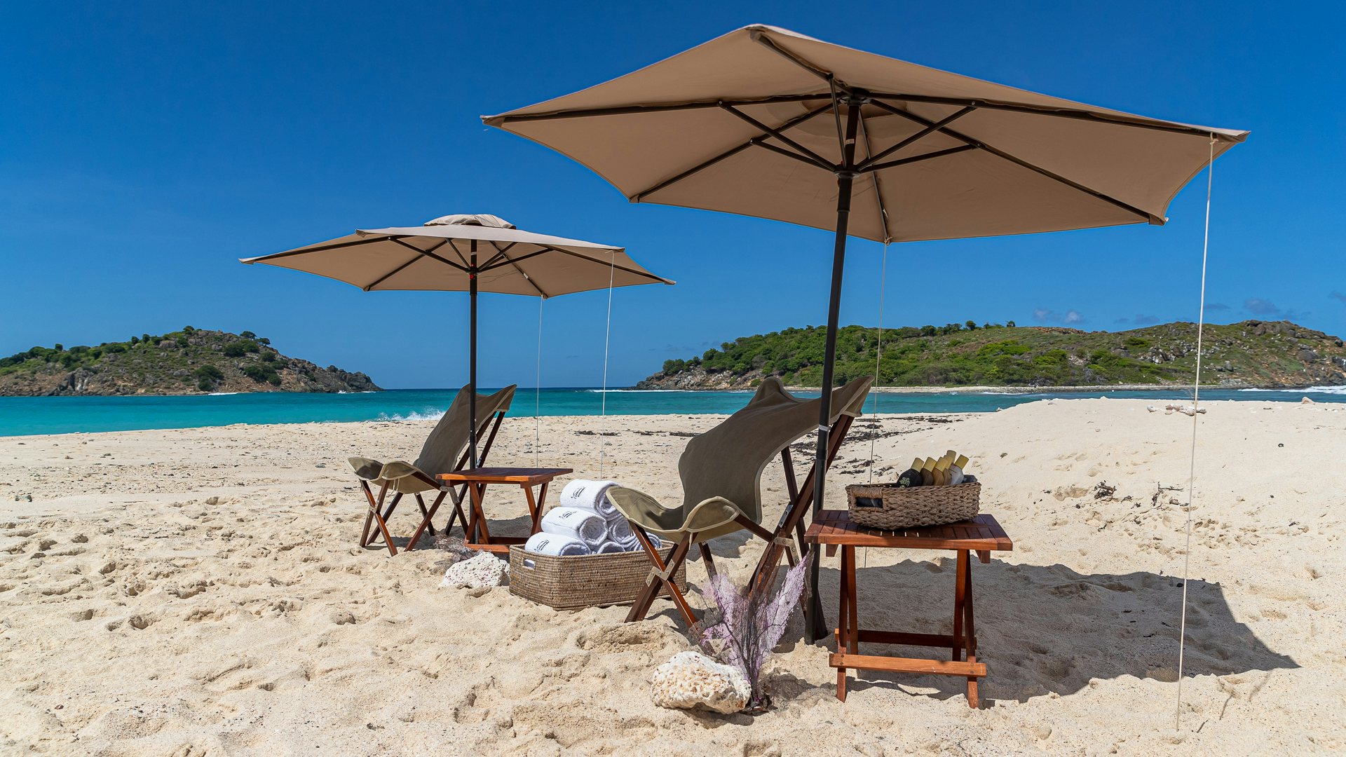 a couple of chairs and an umbrella on a beach aboard MILESTONE Yacht for Charter