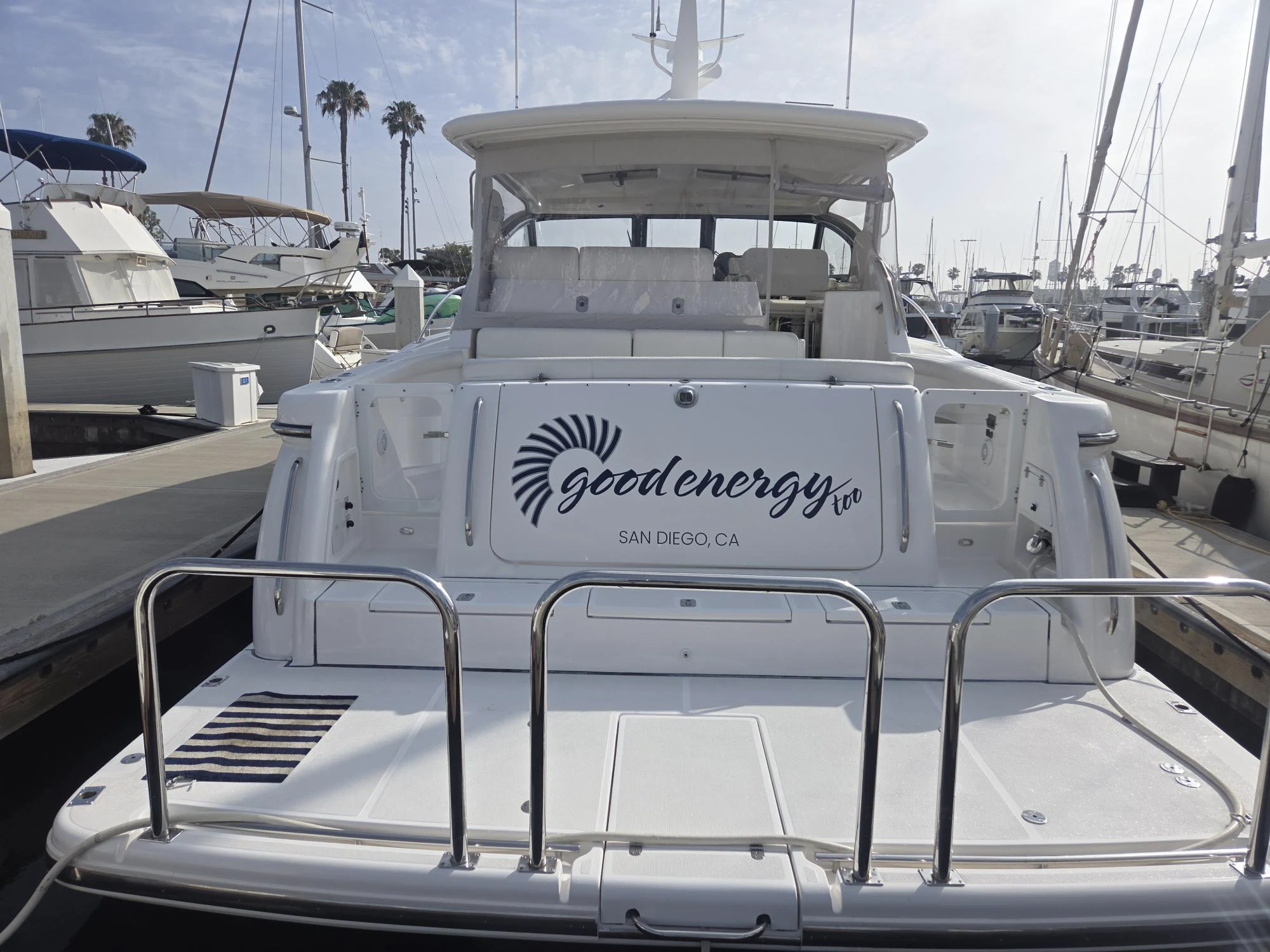 a white boat with a sign on it aboard GOOD ENERGY TOO Yacht for Sale