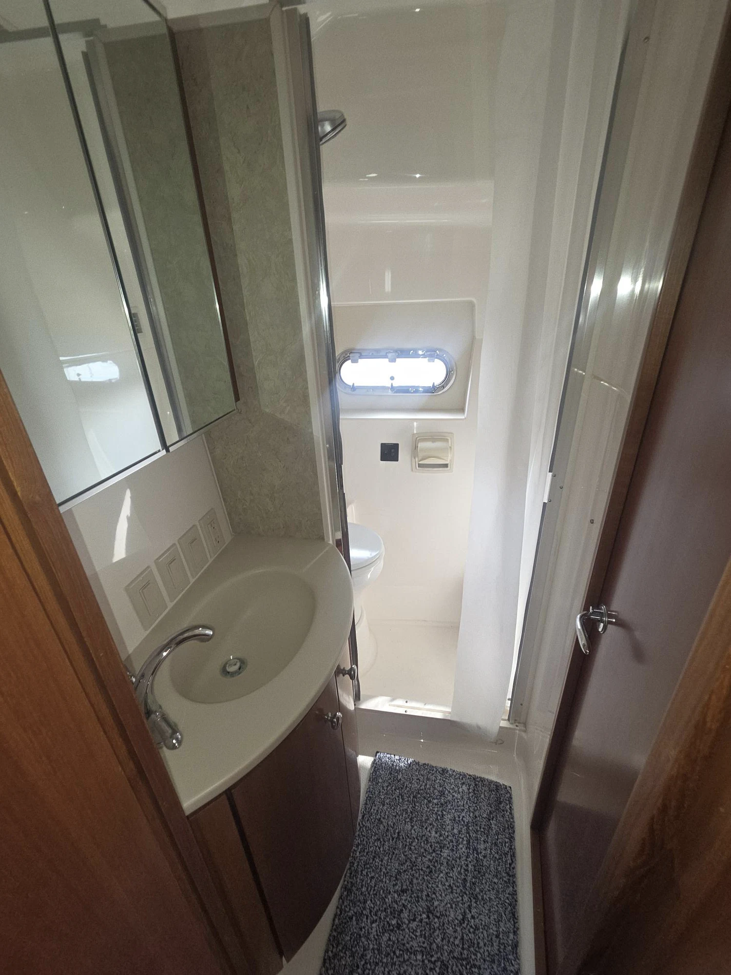 a bathroom with a round mirror aboard GOOD ENERGY TOO Yacht for Sale