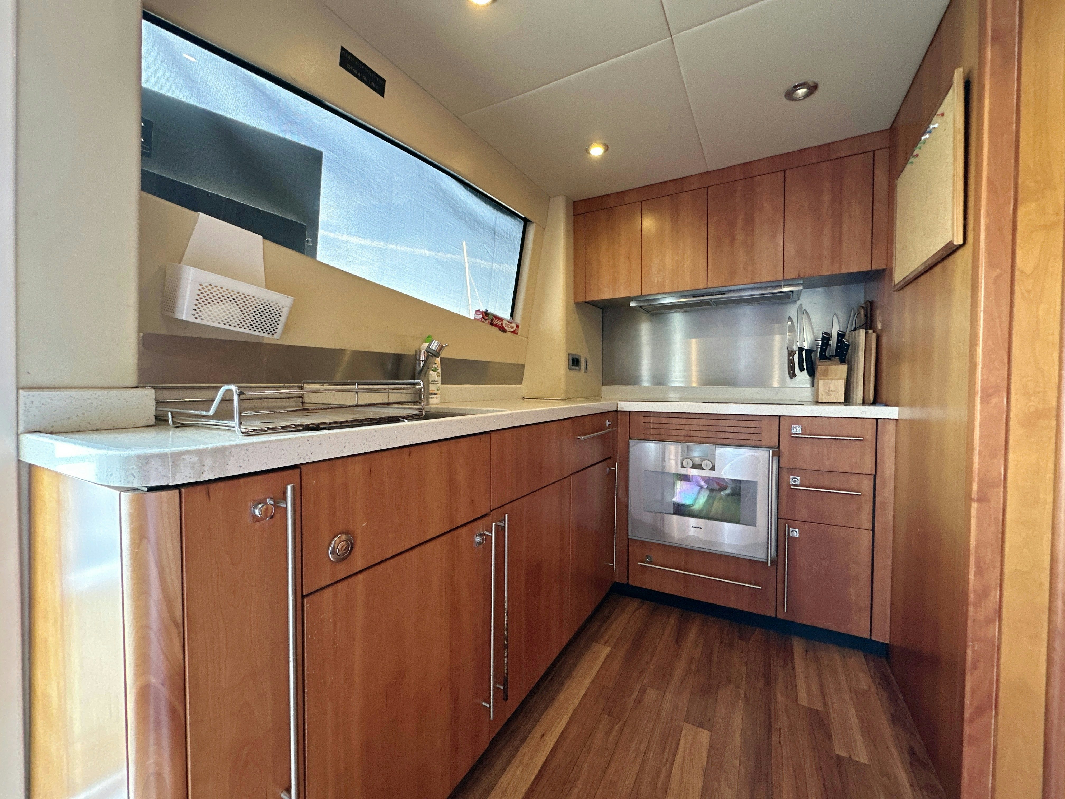 a kitchen with wooden cabinets aboard SWORDFISH 68 Yacht for Sale