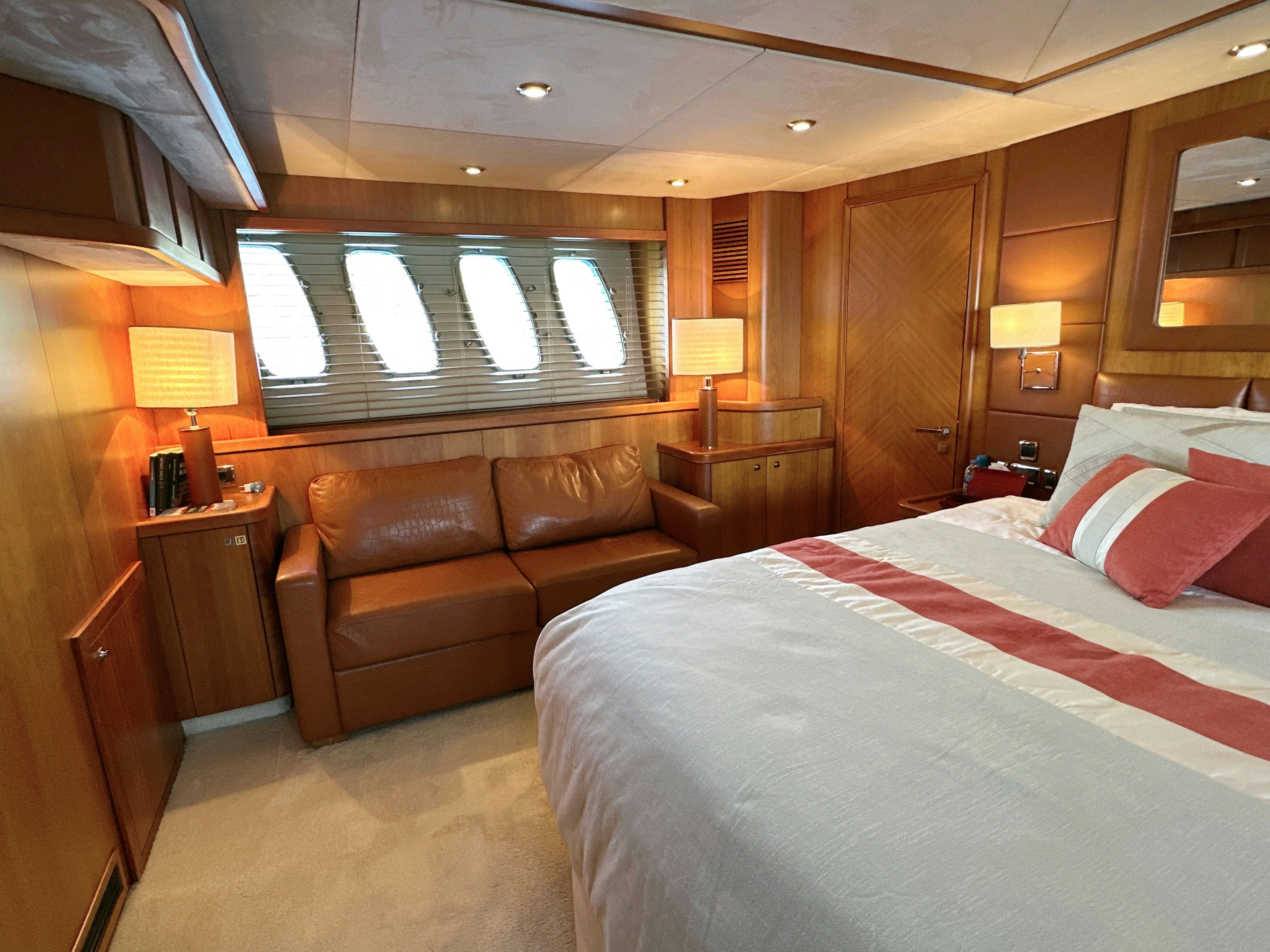 a bedroom with a bed and a couch aboard SWORDFISH 68 Yacht for Sale