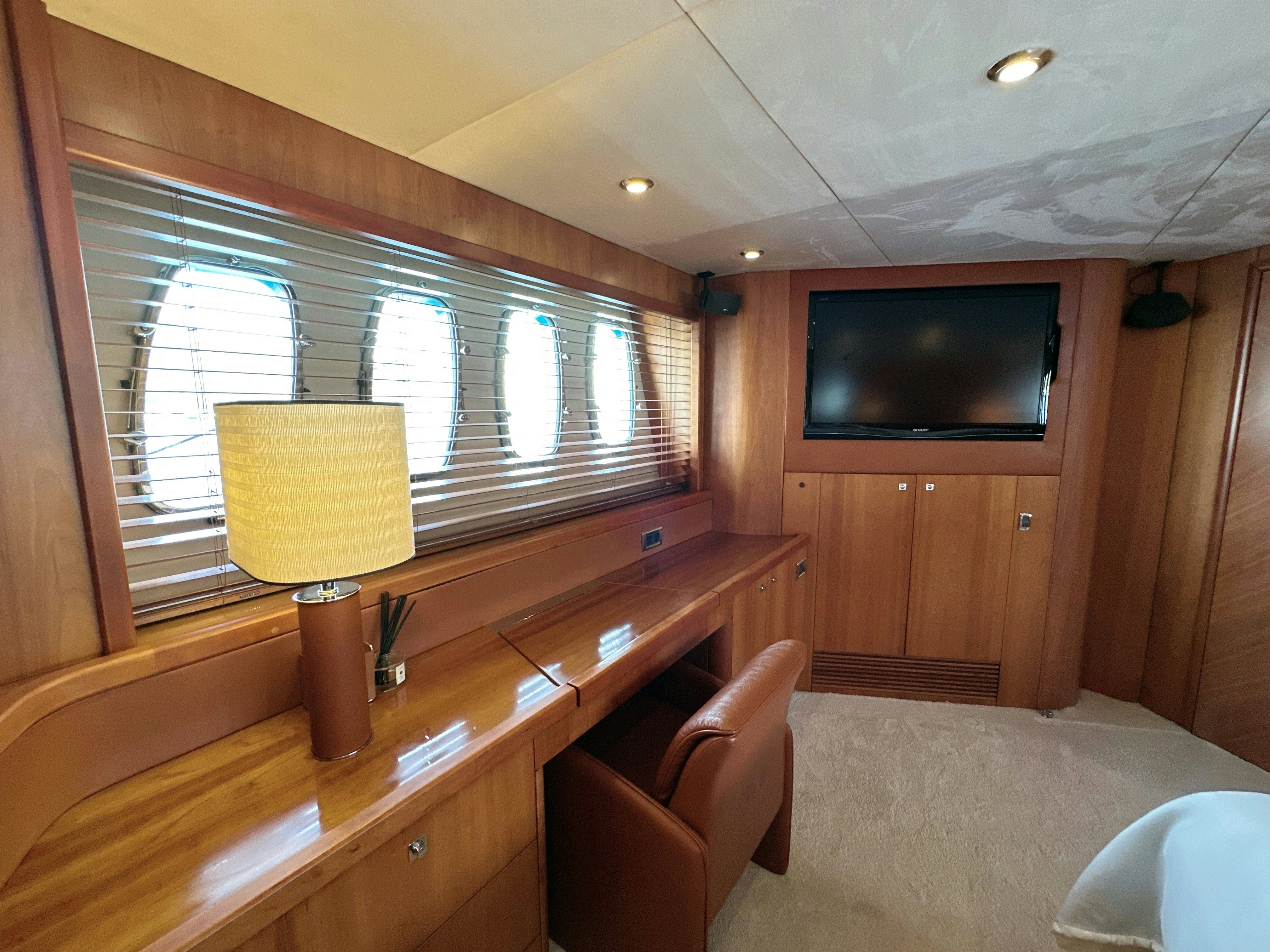 a room with a tv and a table aboard SWORDFISH 68 Yacht for Sale