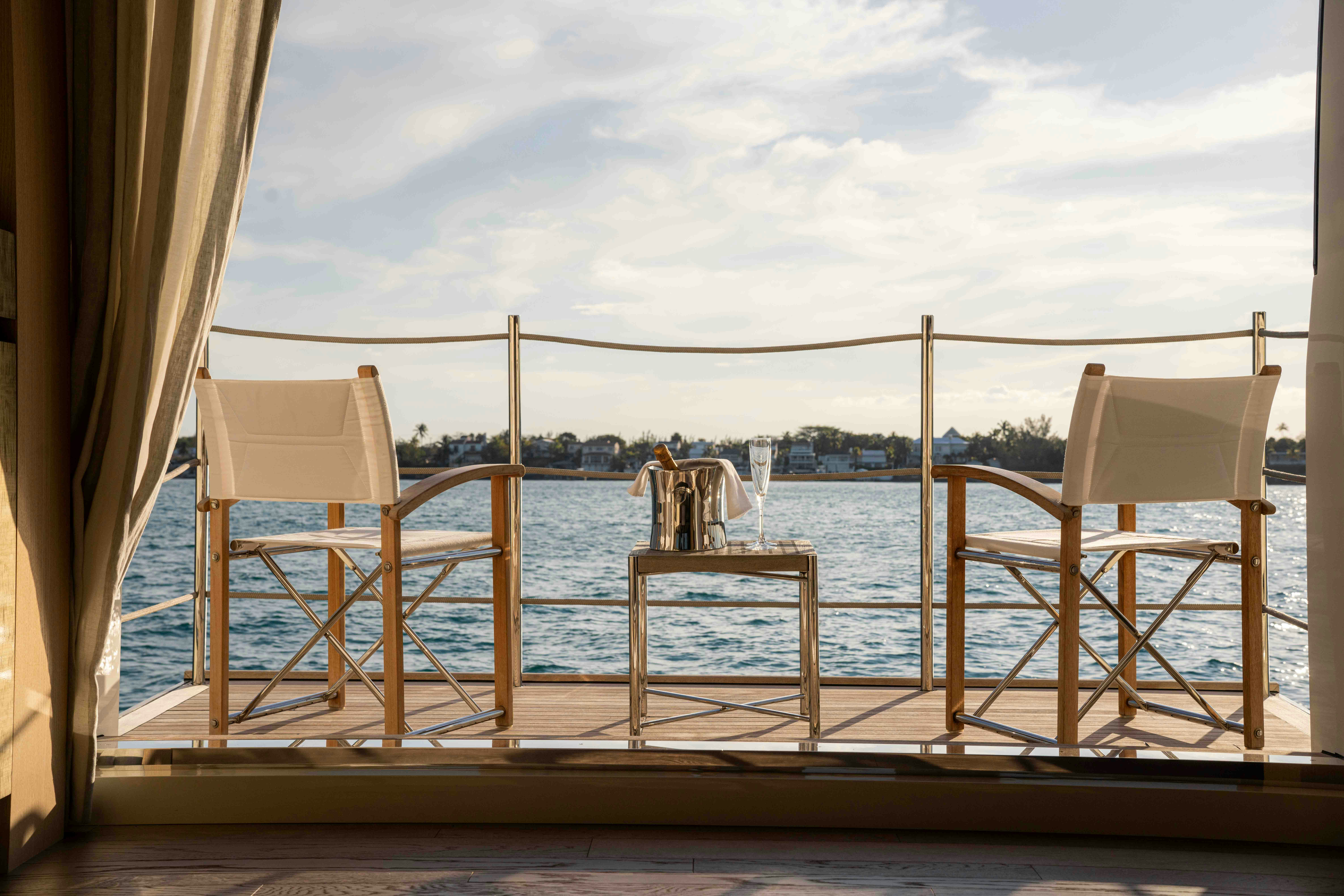 a deck with chairs and a body of water in the background aboard PREMURA Yacht for Charter
