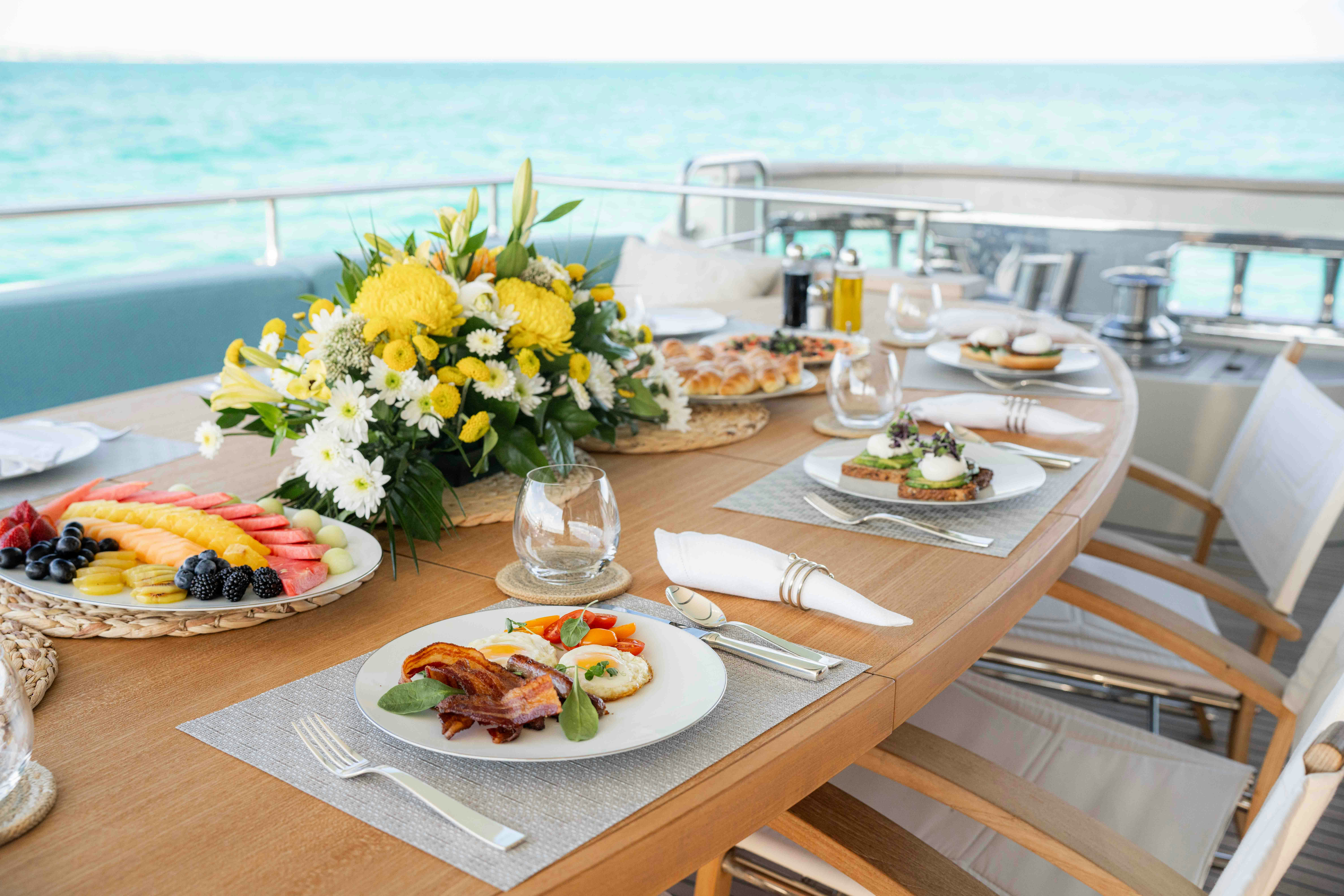 a table with plates of food and glasses on it aboard PREMURA Yacht for Charter
