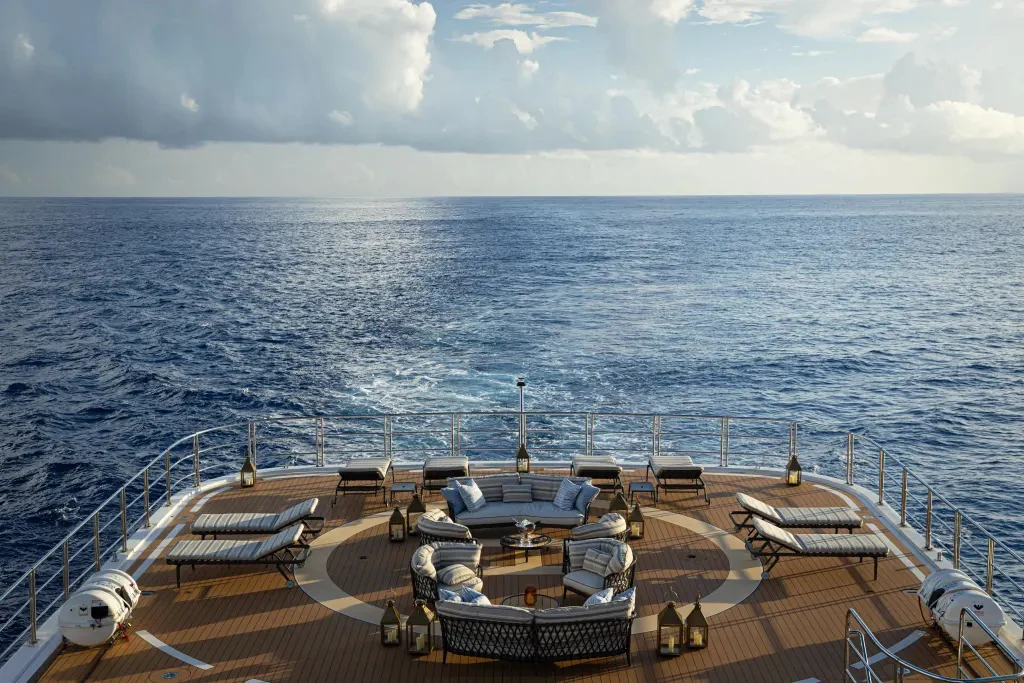 a deck with chairs and a boat on it aboard LEGEND Yacht for Charter