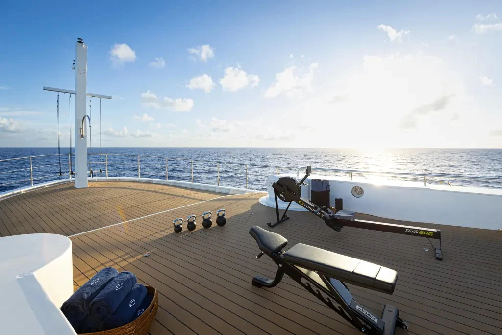 a deck with a bench and a body of water in the background aboard LEGEND Yacht for Charter
