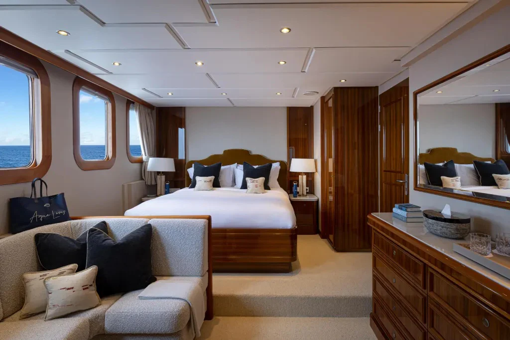 a bedroom with a bed and a couch aboard LEGEND Yacht for Charter