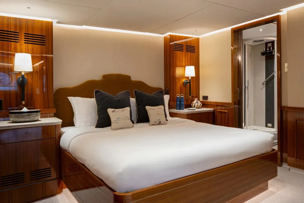 a bed with a white comforter aboard LEGEND Yacht for Charter