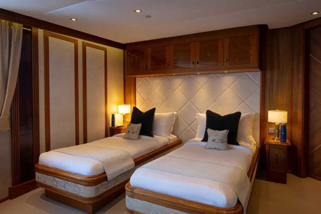 a couple of beds in a hotel room aboard LEGEND Yacht for Charter