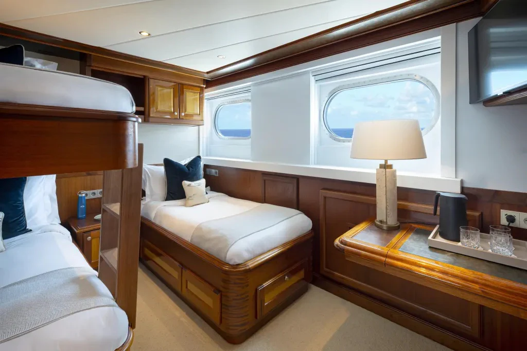 a room with a bed and a desk aboard LEGEND Yacht for Charter