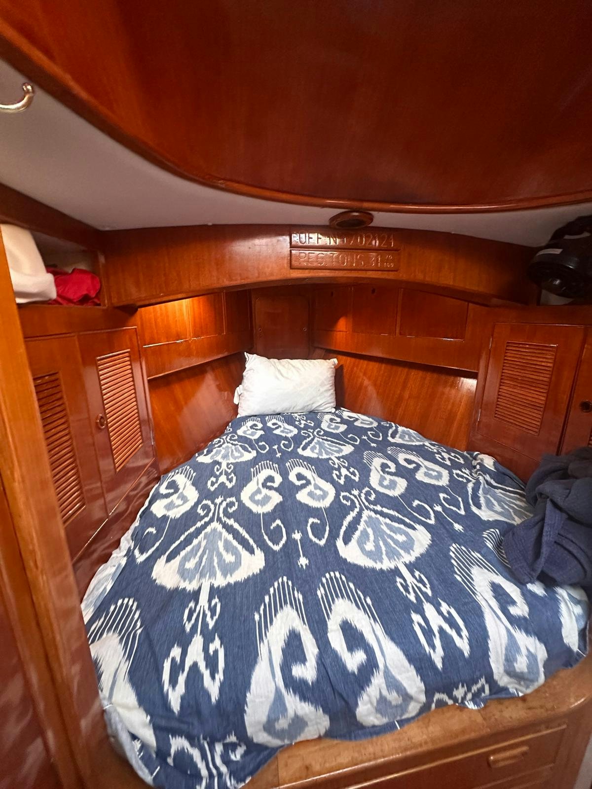 a bed with a blue and white blanket aboard II Yacht for Sale