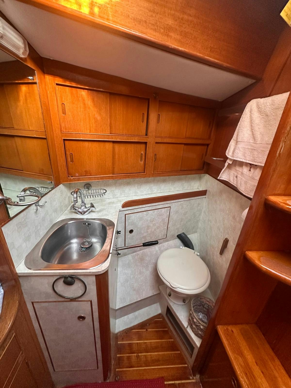 a bathroom with wooden cabinets aboard II Yacht for Sale