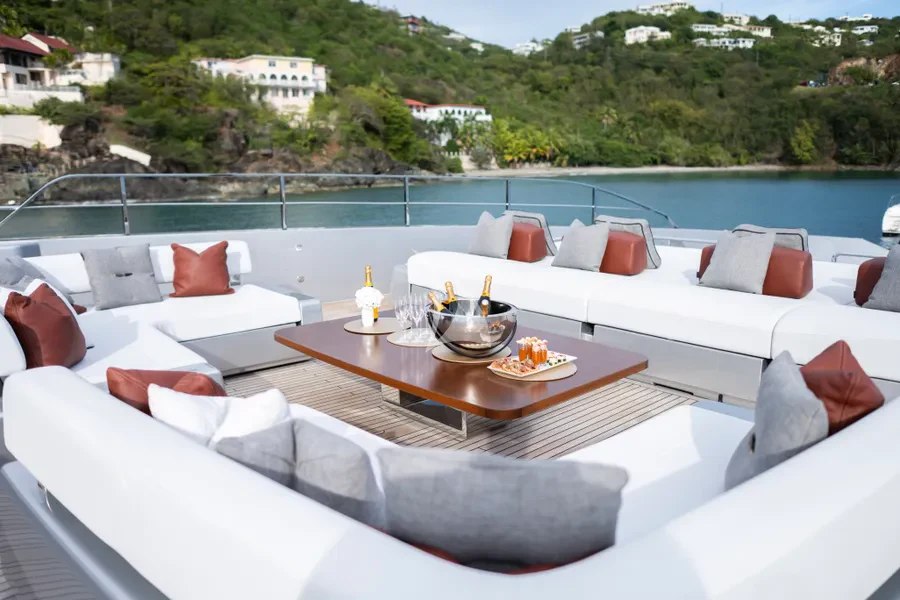 a table with a bowl of food on it next to a couch and a pool aboard TASTY WAVES Yacht for Charter