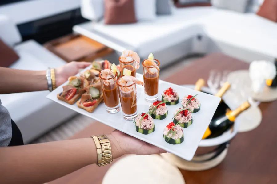 a person holding a plate of food aboard TASTY WAVES Yacht for Charter