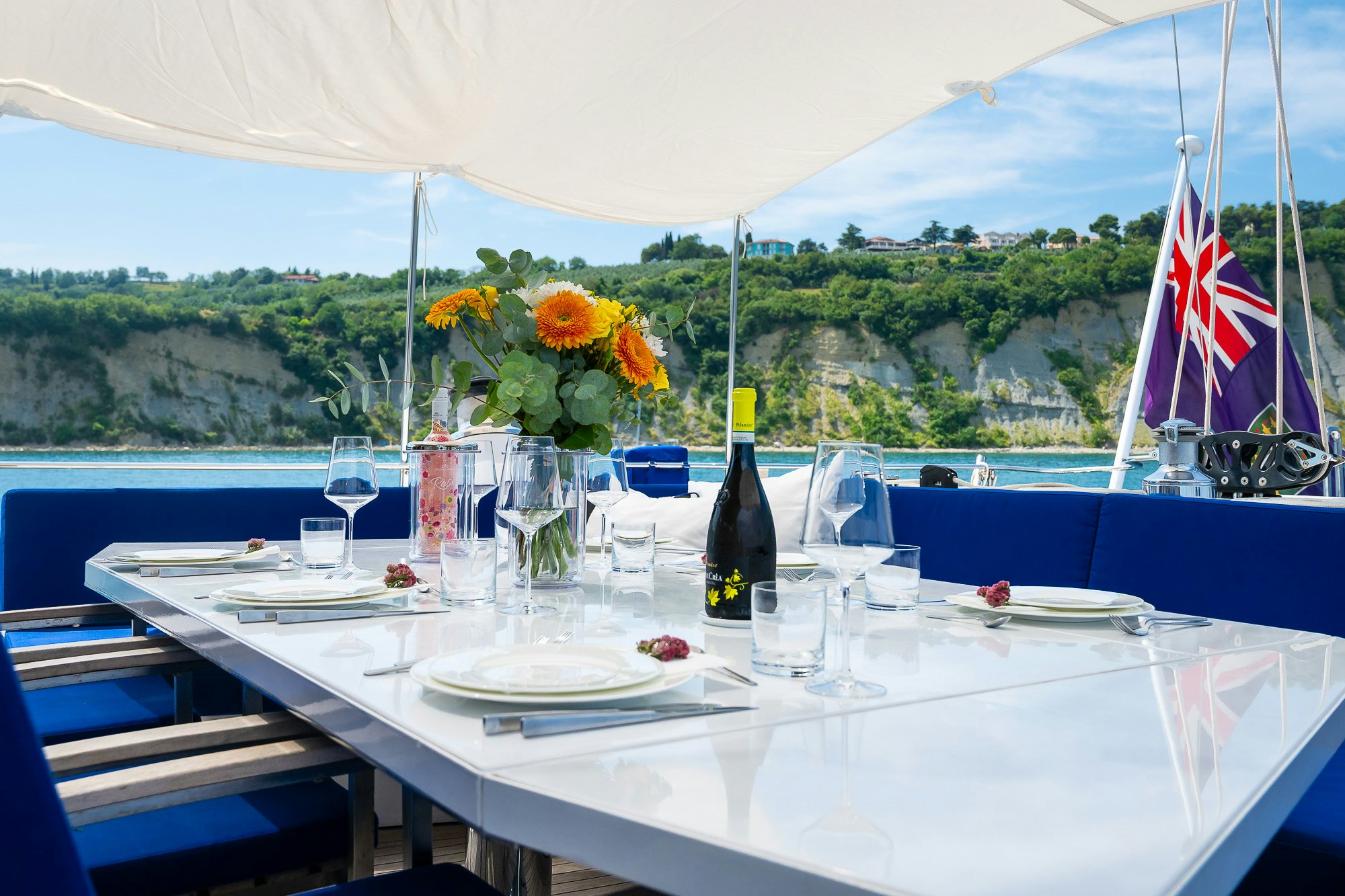 a table with wine glasses and flowers aboard PLAYMOBIL Yacht for Sale