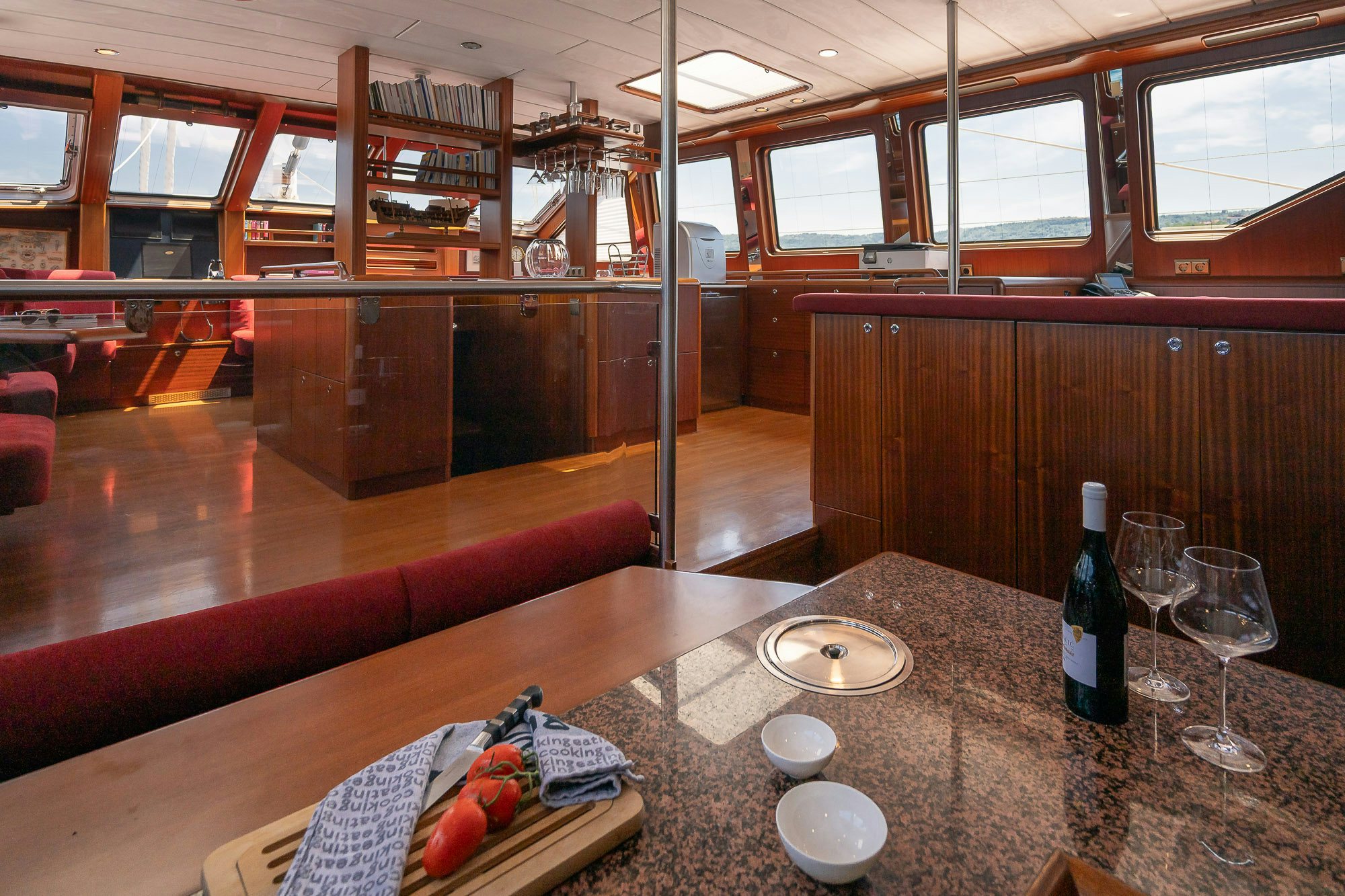 a table with wine glasses and bottles aboard PLAYMOBIL Yacht for Sale