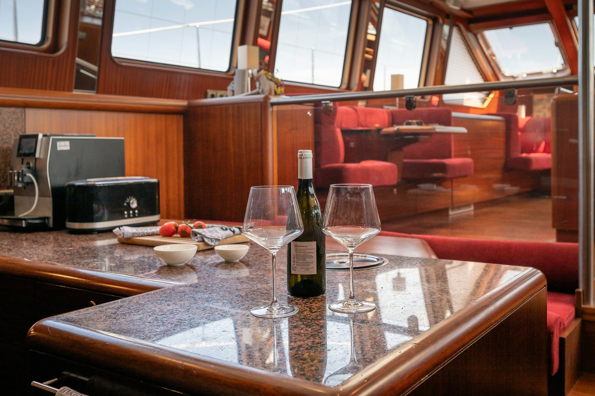 a wine bottle and glasses on a table aboard PLAYMOBIL Yacht for Sale
