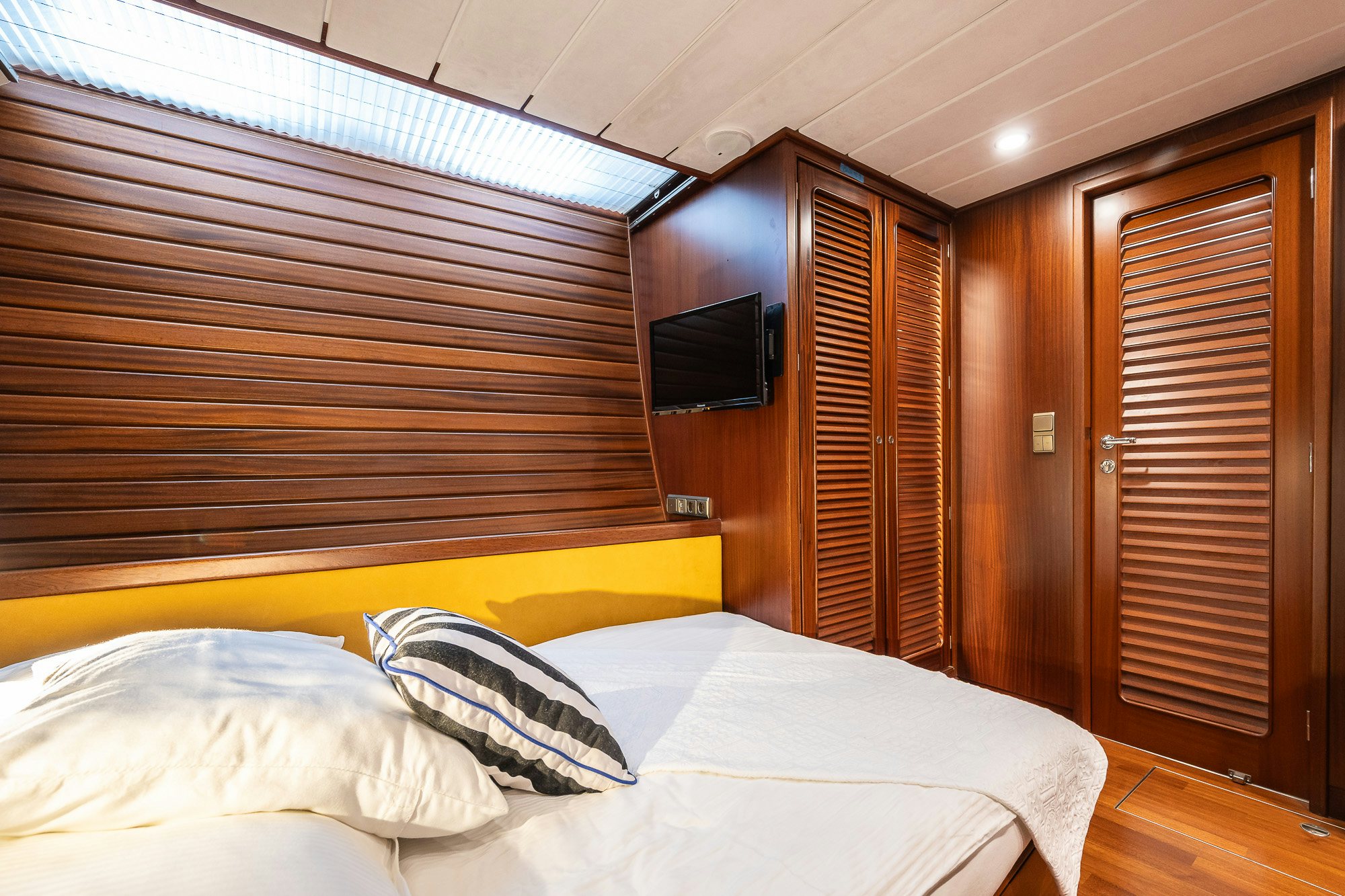 a room with a bed and a television aboard PLAYMOBIL Yacht for Sale