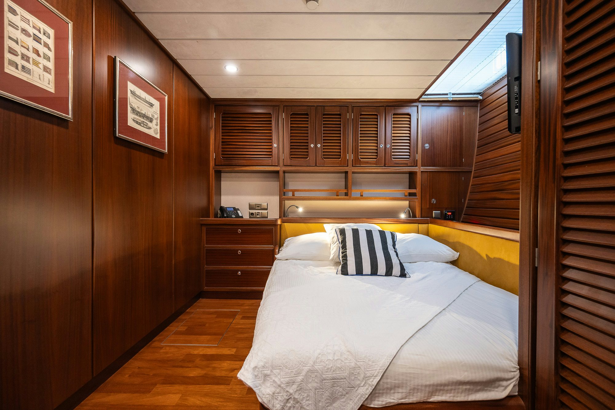 a room with a bed and a wood cabinet aboard PLAYMOBIL Yacht for Sale