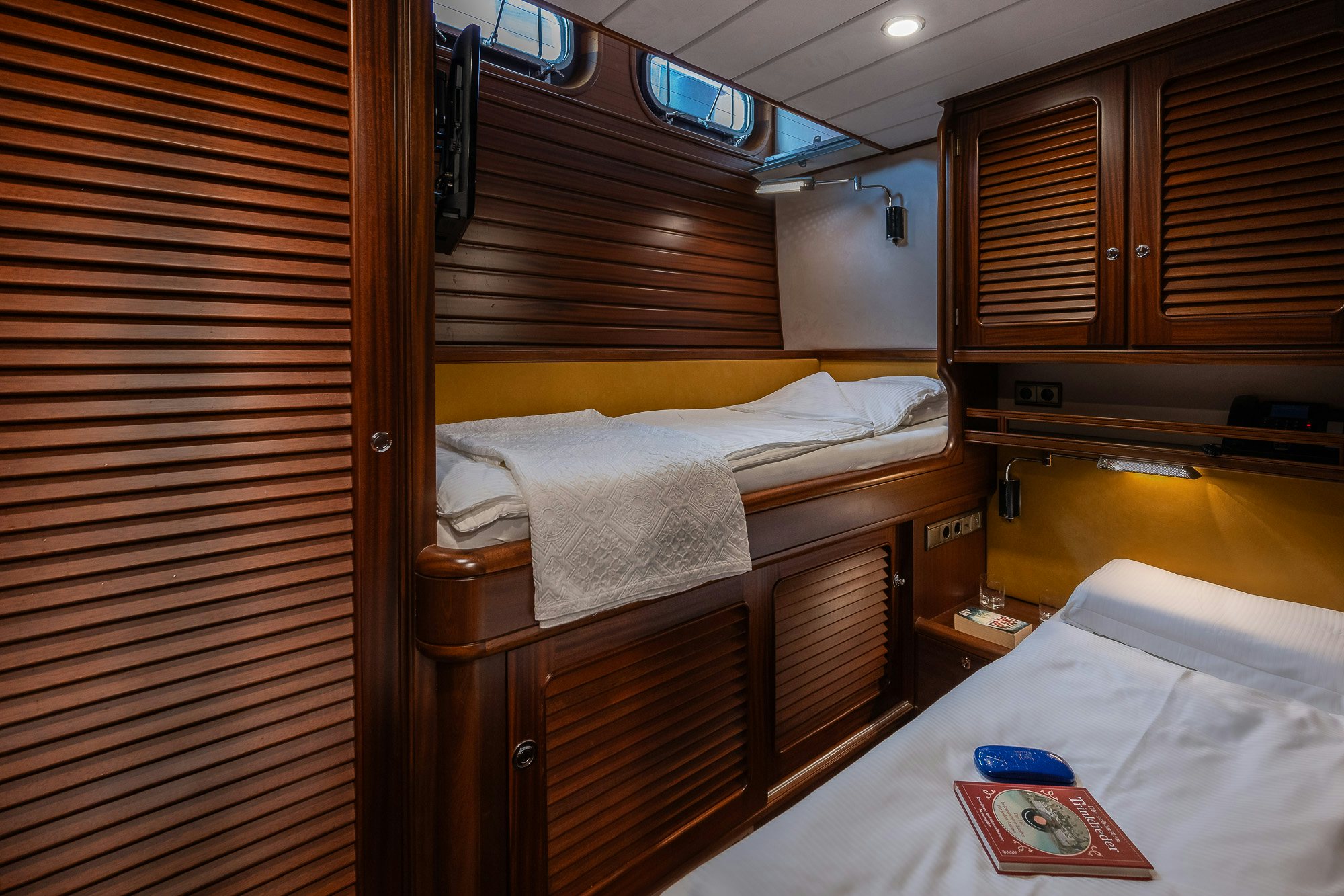 a room with a bed and a desk aboard PLAYMOBIL Yacht for Sale