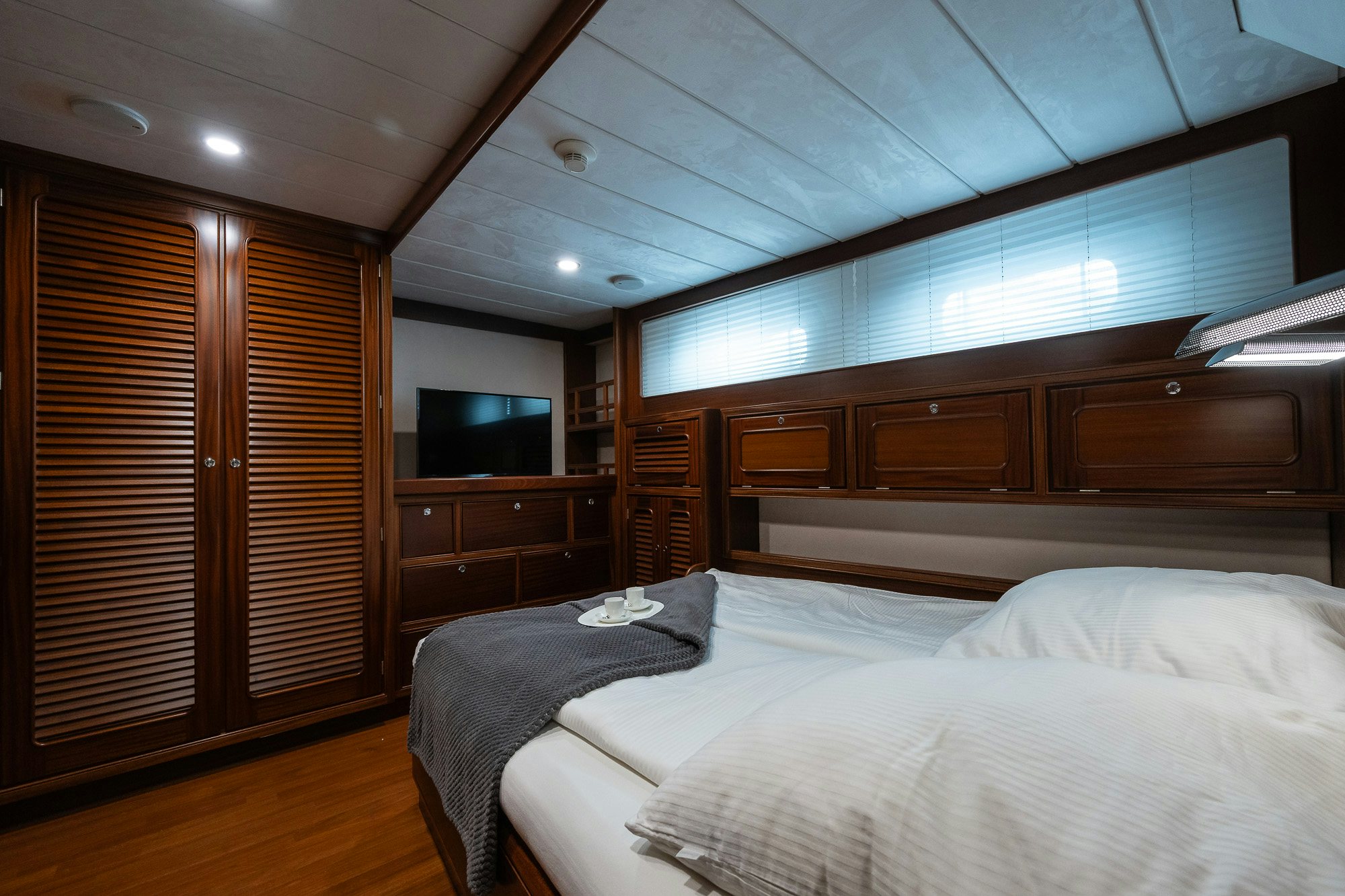 a room with a bed and a television aboard PLAYMOBIL Yacht for Sale