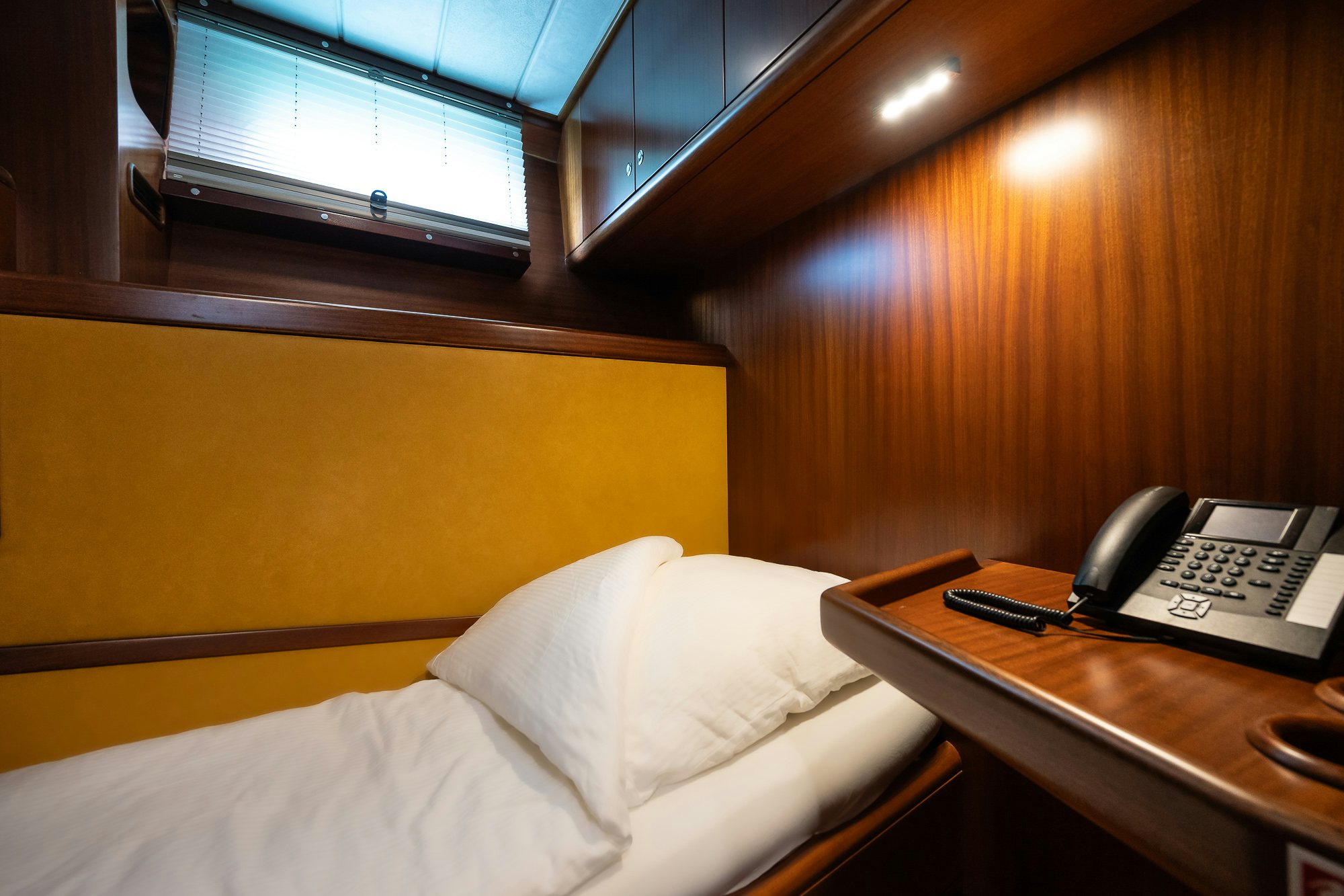 a bed with a phone on it aboard PLAYMOBIL Yacht for Sale
