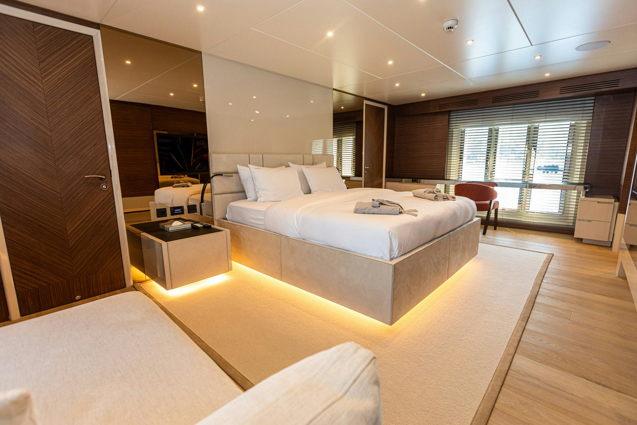 a large hotel room with a large bed and a table aboard ZEEMAR Yacht for Charter