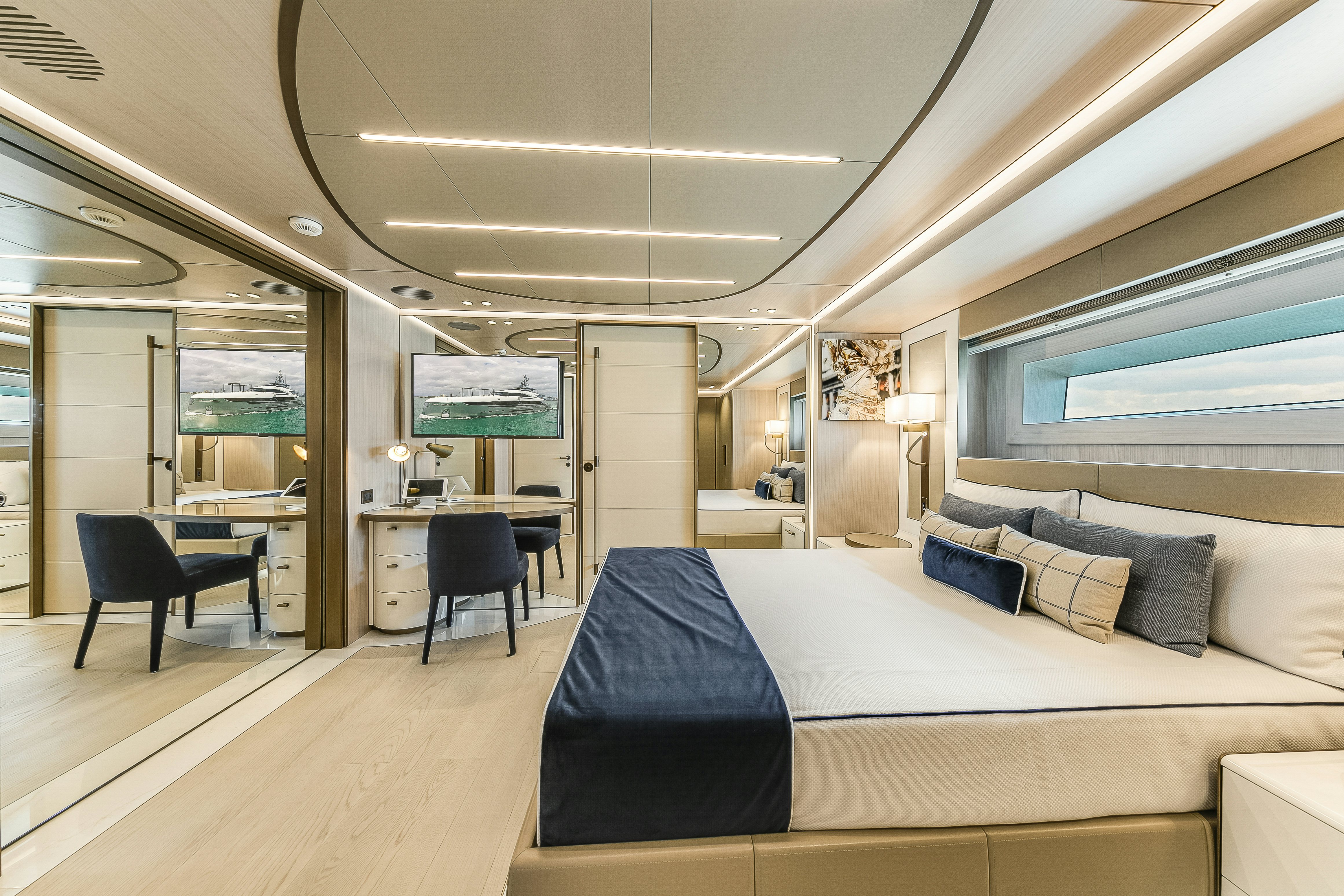 a bedroom with a bed and a desk aboard EIV Yacht for Sale