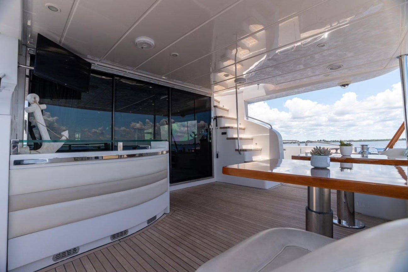 a room with a large window and a table with chairs and a view of the water aboard VIXEN Yacht for Sale