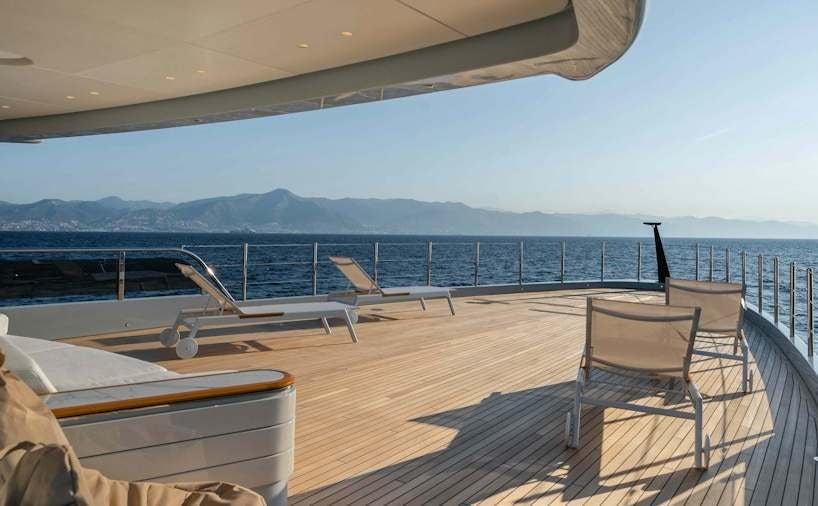 a deck with chairs and a body of water in the background aboard SERENISSIMA I Yacht for Charter