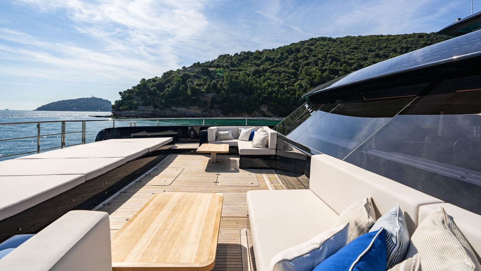 a deck with a view of a mountain and water aboard PETITE BELLE Yacht for Sale
