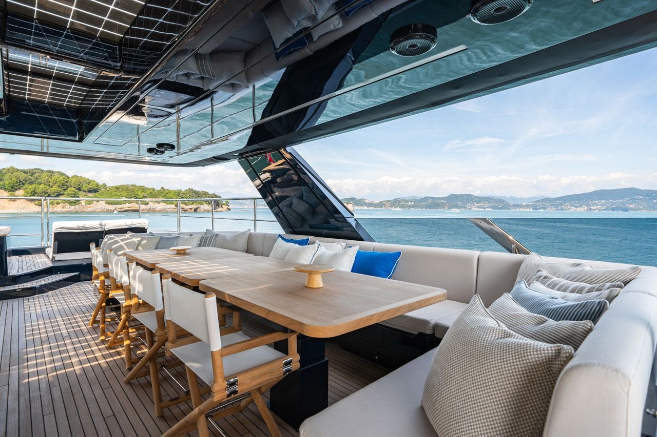 a deck with a table and chairs on it aboard PETITE BELLE Yacht for Sale