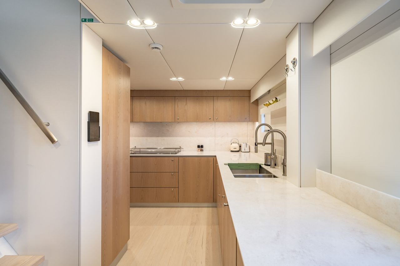 a kitchen with wooden cabinets aboard PETITE BELLE Yacht for Sale