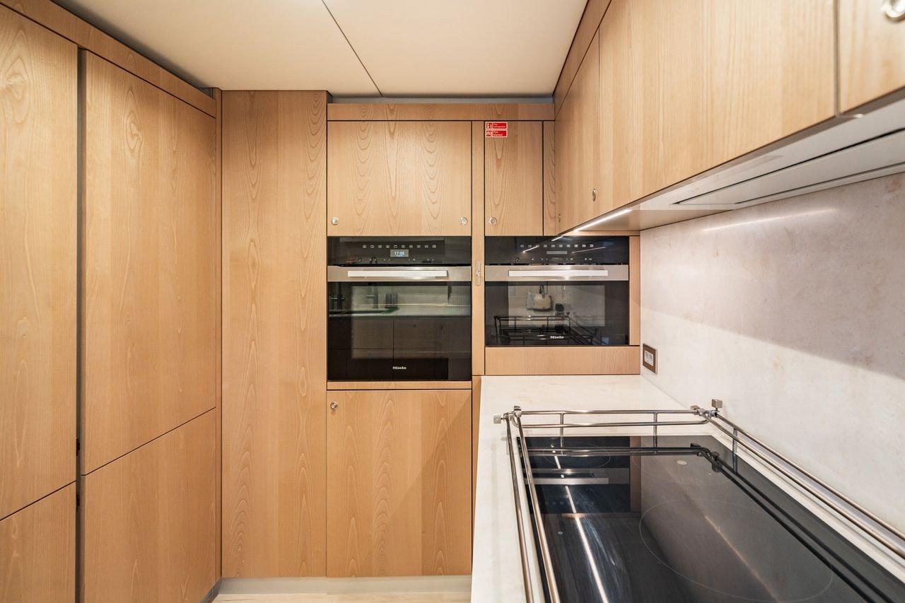 a kitchen with wooden cabinets aboard PETITE BELLE Yacht for Sale