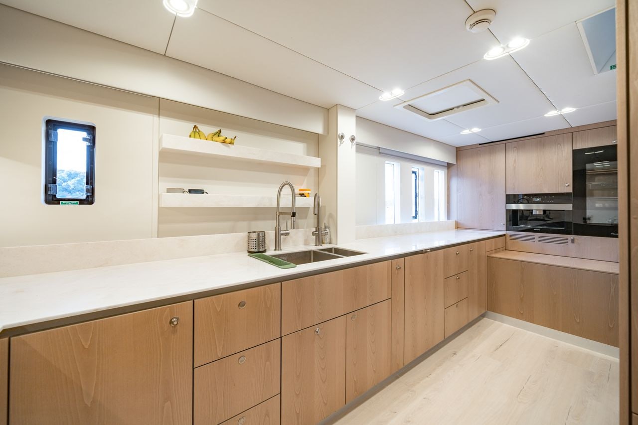 a kitchen with wooden cabinets aboard PETITE BELLE Yacht for Sale