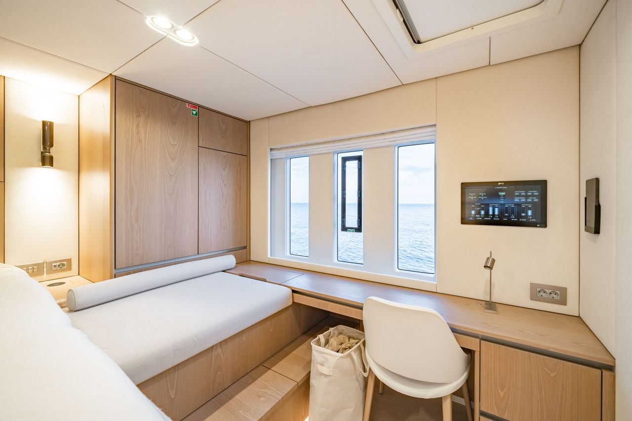 a room with a desk and a bed aboard PETITE BELLE Yacht for Sale