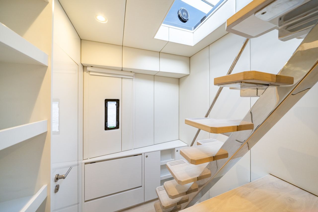 a white room with a staircase and a wood railing aboard PETITE BELLE Yacht for Sale