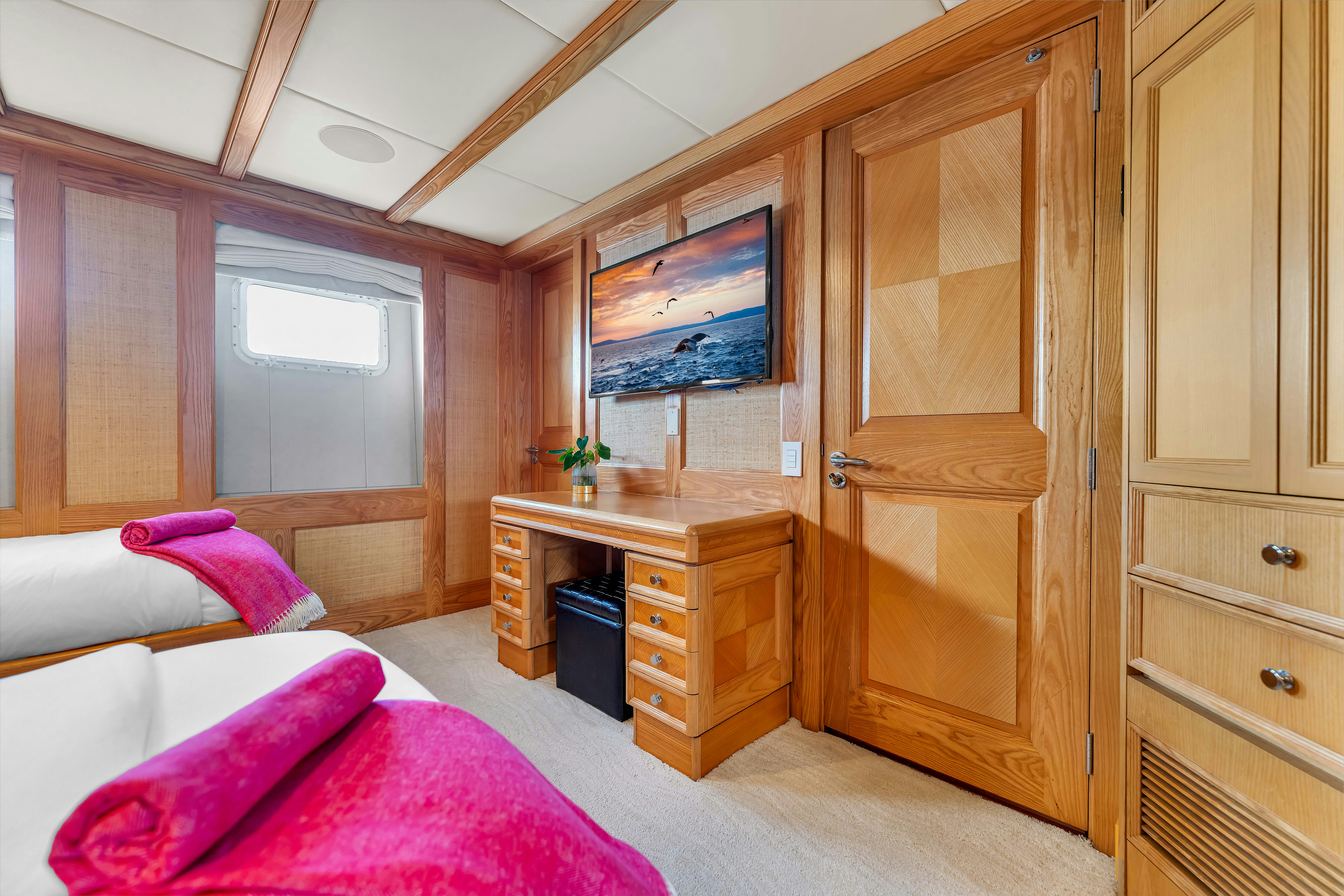 a bedroom with a bed and a desk aboard STAR DIAMOND Yacht for Charter