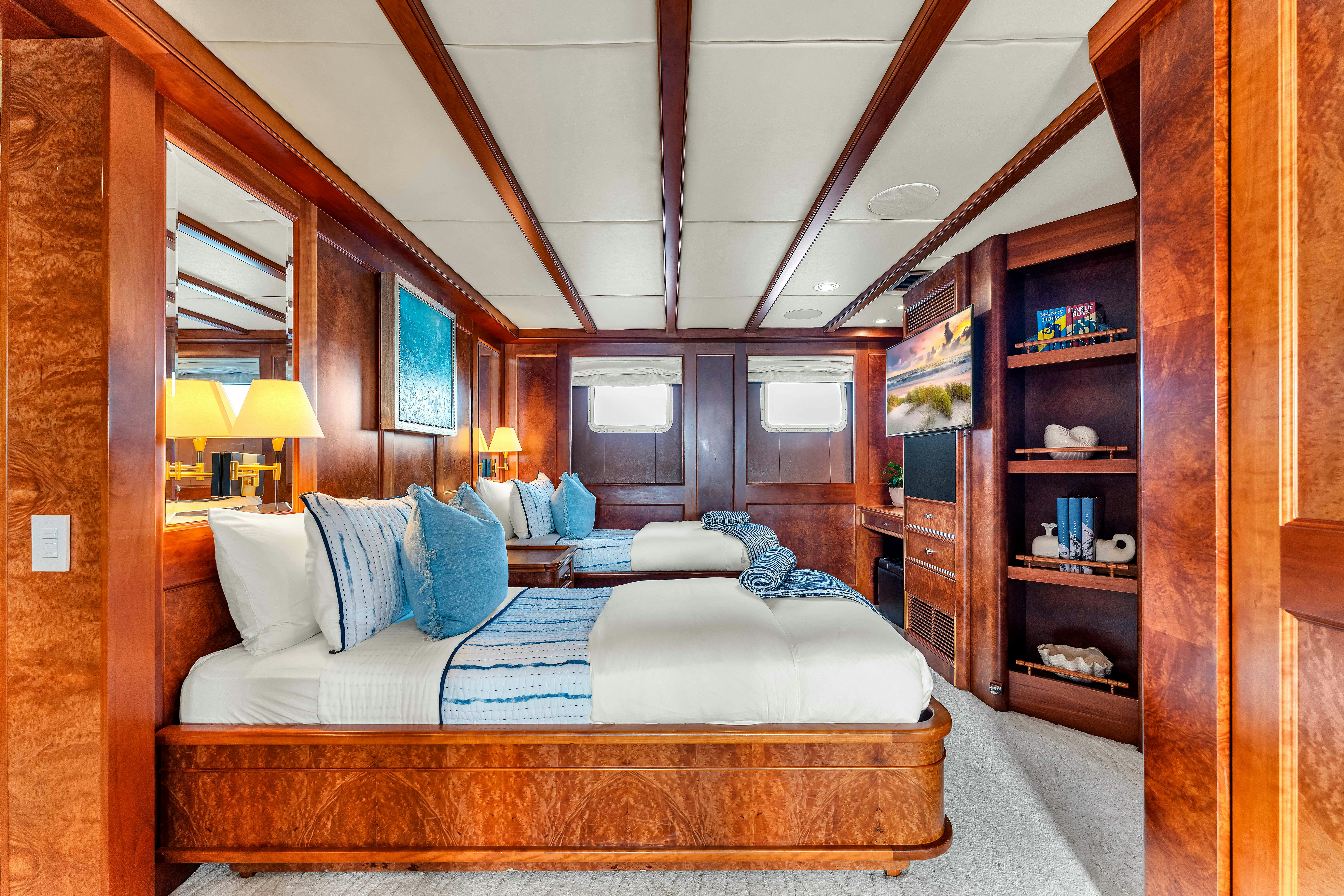 a large living room with a large bed and a bookcase aboard STAR DIAMOND Yacht for Charter