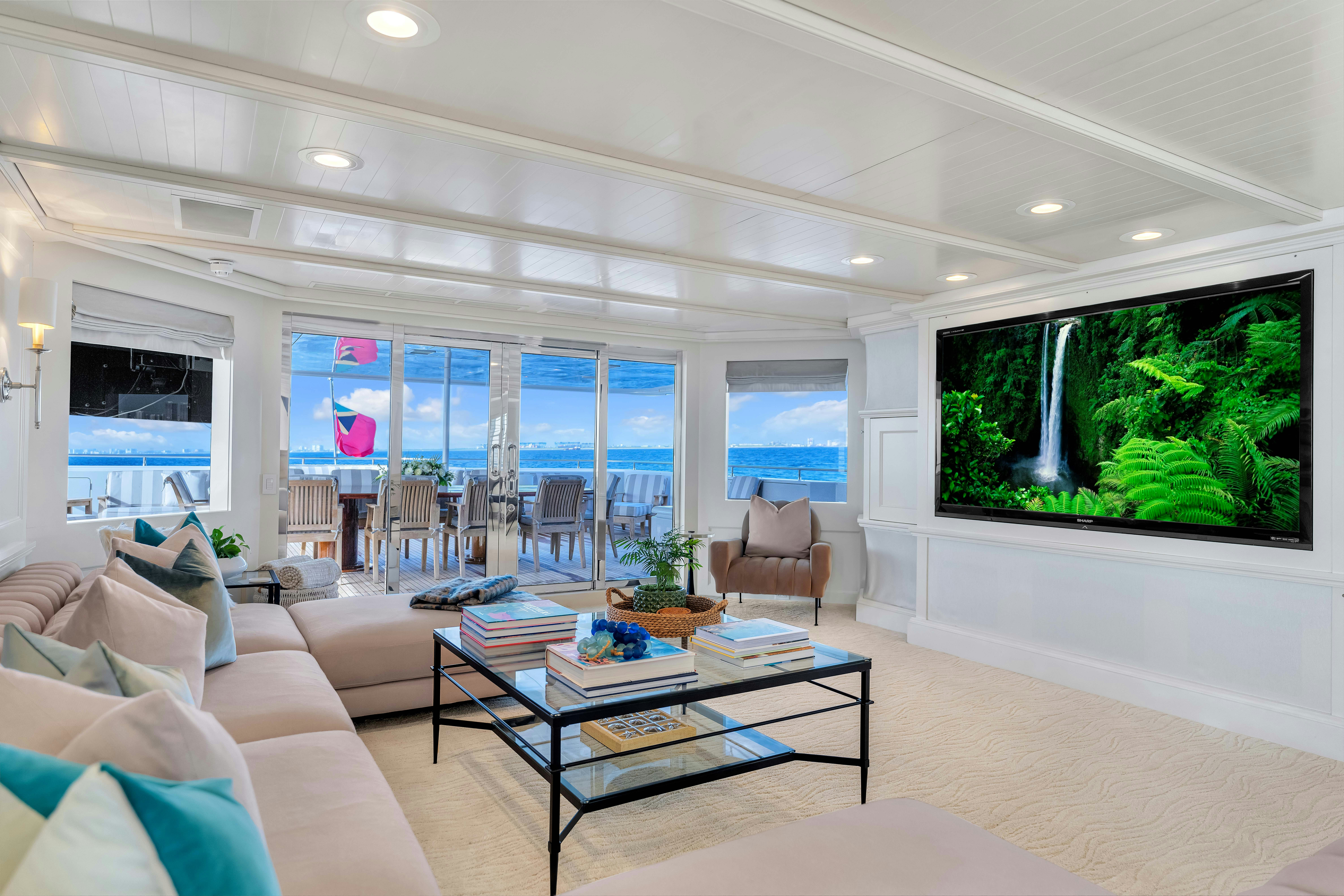 a living room with a large screen aboard STAR DIAMOND Yacht for Charter