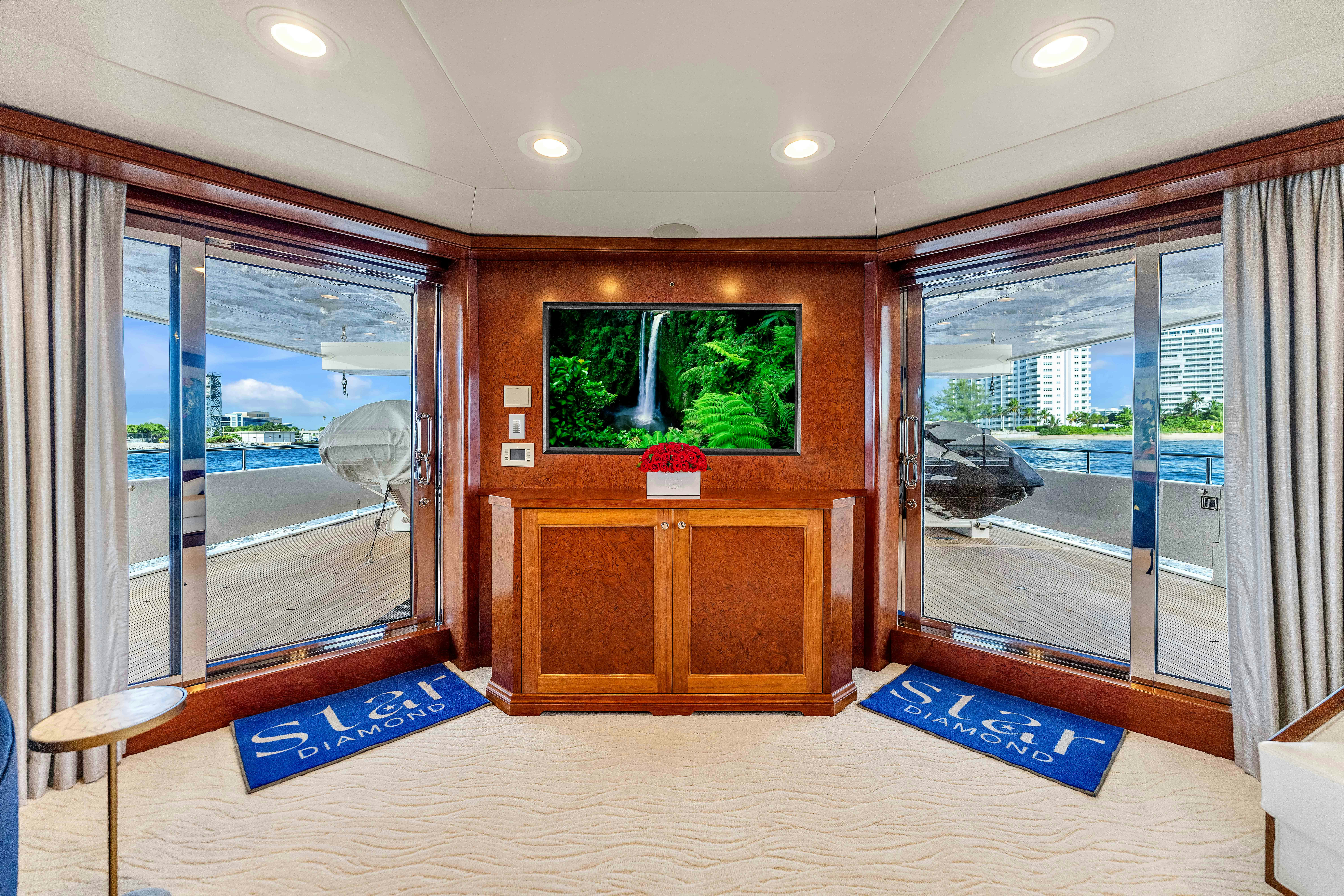 a room with a large window and a large wood cabinet with a painting on it aboard STAR DIAMOND Yacht for Charter