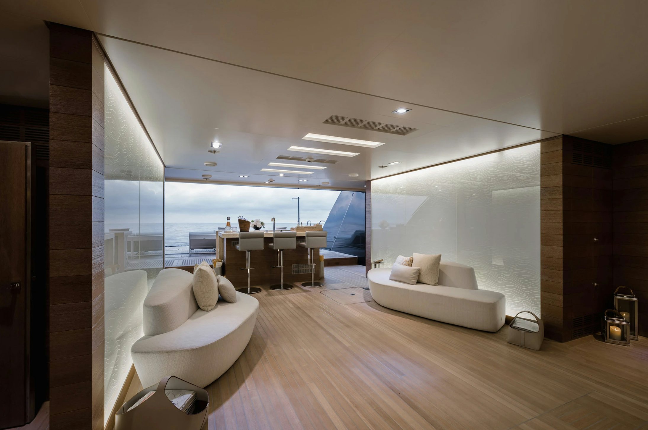 a room with a couch and a table and a large window aboard LOON Yacht for Charter