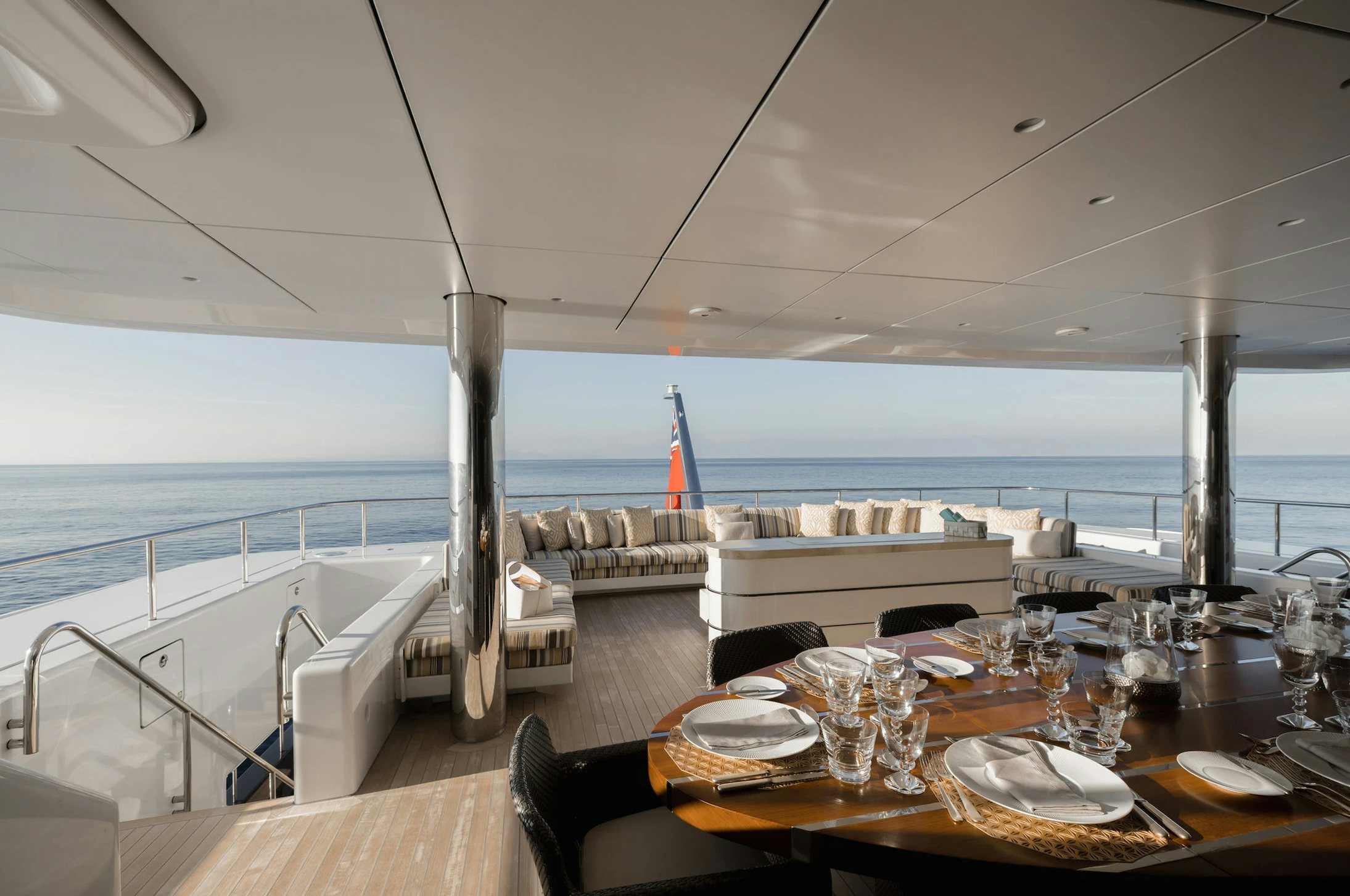 a table set for a meal on a balcony overlooking the ocean aboard LOON Yacht for Charter