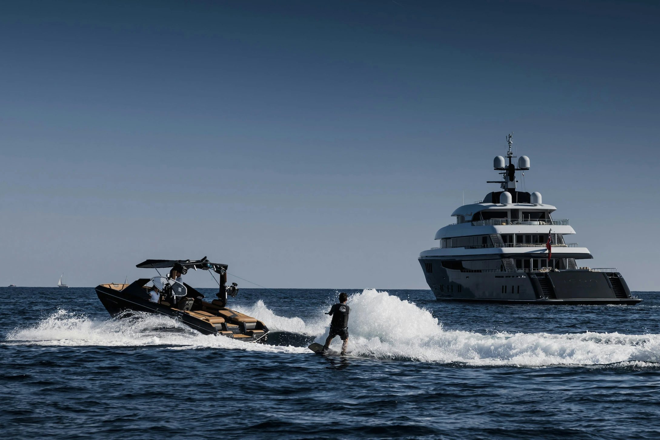a man surfing next to a boat aboard LOON Yacht for Charter